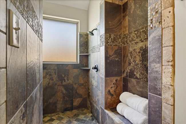 Full bathroom with tiled shower and stone finish flooring | Image 26