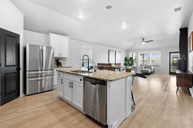 Continuing through the home, you'll find a desirable, open concept kitchen, dining, and living area. | Image 6