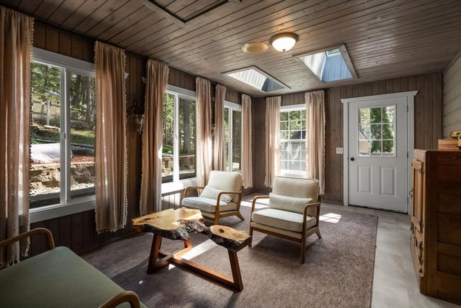 Sunroom / solarium featuring a skylight and wood walls | Image 25