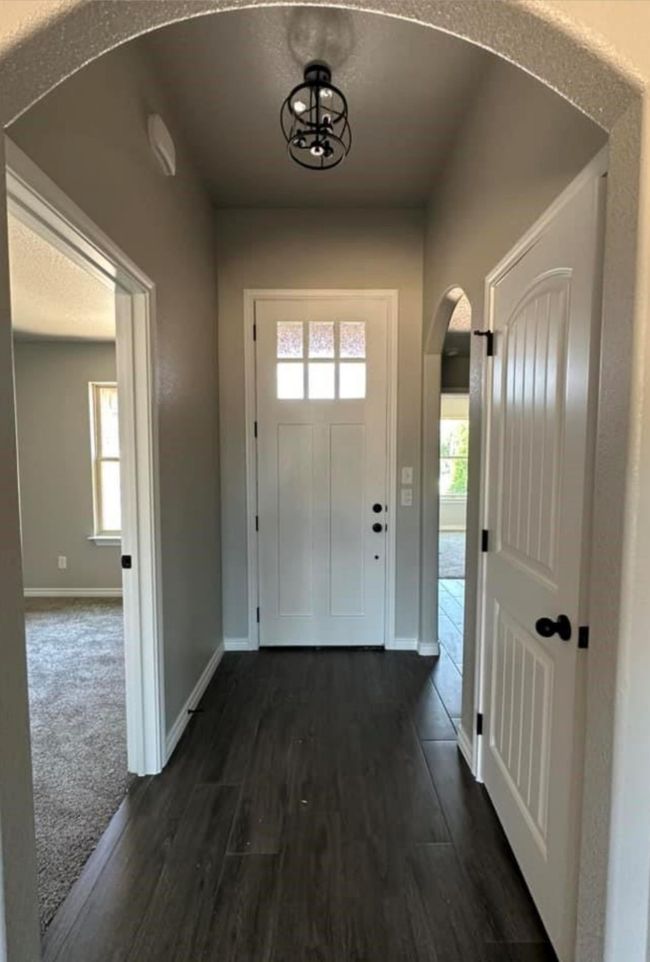 Entryway with arched walkways and dark wood-style floors | Image 4