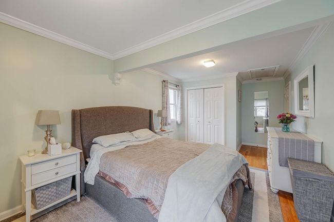 Bedroom with attic access, crown molding, wood finished floors, and a closet | Image 31