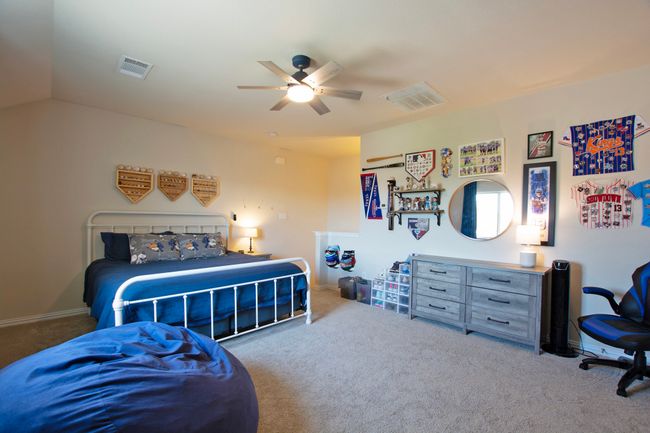 Carpeted bedroom featuring baseboards, ceiling fan, and visible vents | Image 27