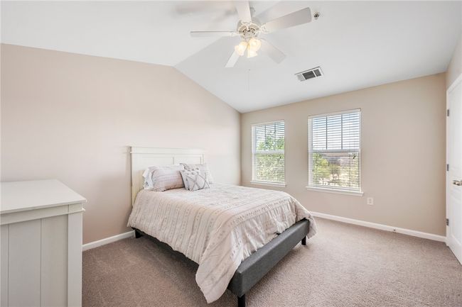 Carpeted bedroom featuring lofted ceiling, visible vents, ceiling fan, and baseboards | Image 12