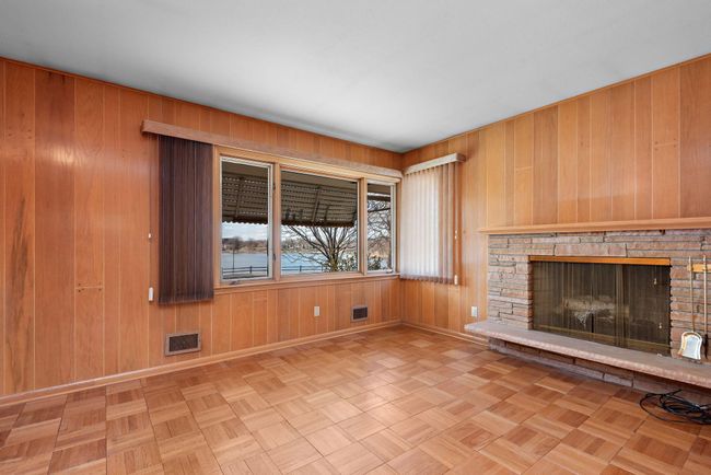 3rd bedroom on main level can serve as an office/den with built-in desk and wood burning fireplace with lake views! | Image 29