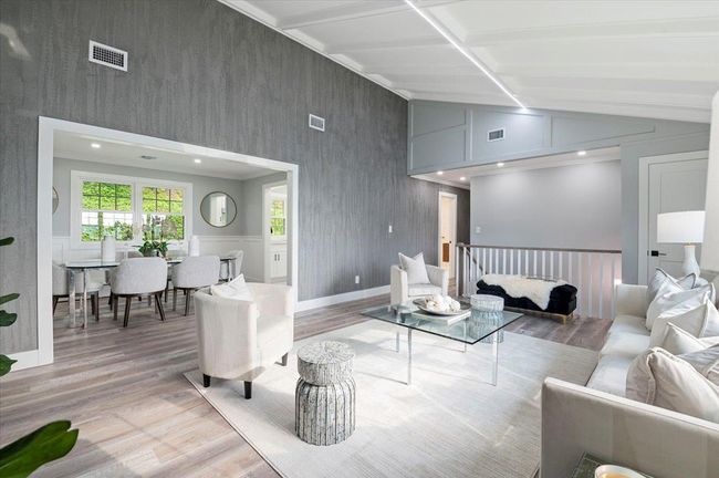 Living area featuring light wood-type flooring, vaulted ceiling, and wallpapered walls | Image 11