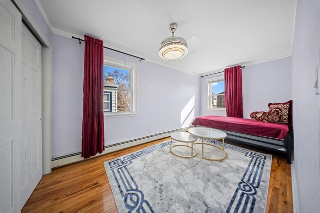 Living area featuring a baseboard heating unit and wood finished floors | Image 18