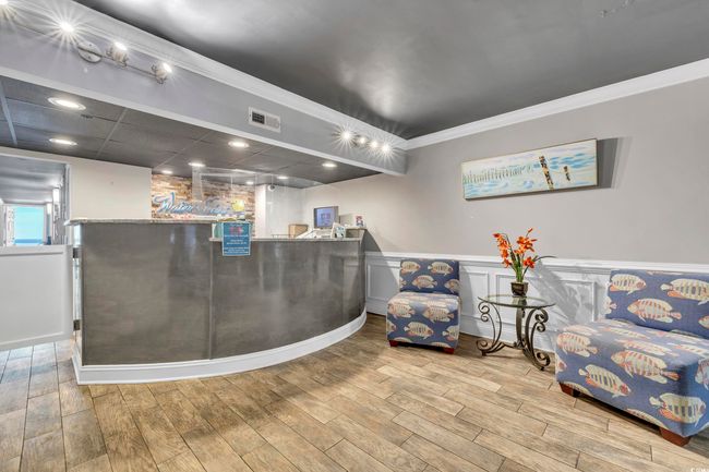Reception area with crown molding, wainscoting, recessed lighting, and a community bar | Image 32