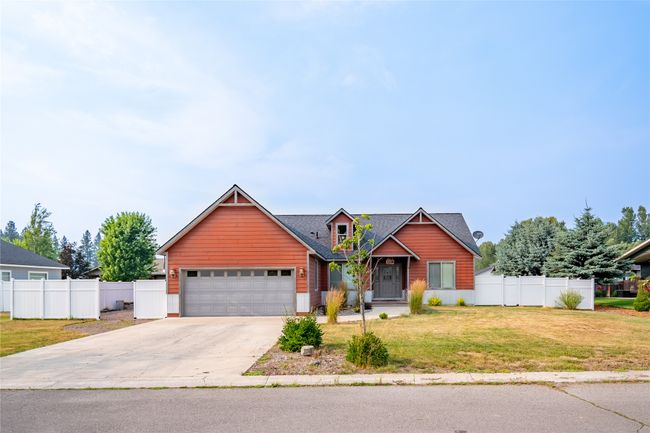 View of front of home featuring a front yard, fence, a garage, and concrete driveway | Image 12