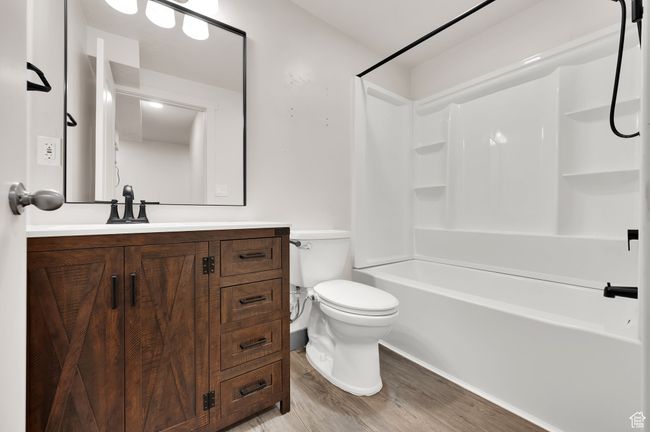 Full bathroom with toilet, shower / tub combination, wood finished floors, and vanity | Image 20