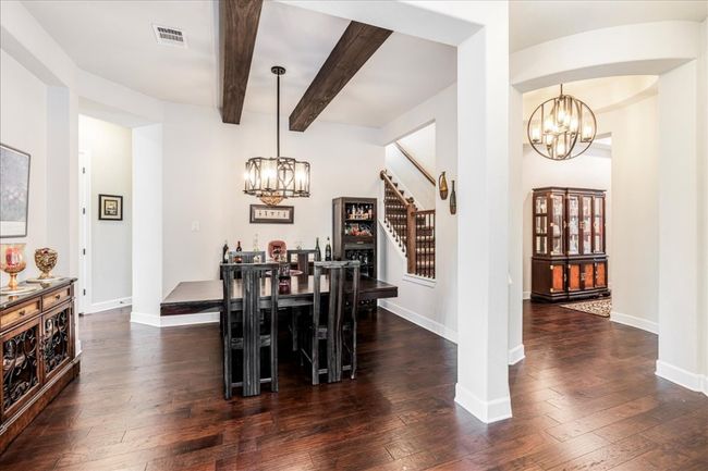 Dining area with a chandelier, stairway, beamed ceiling, and dark wood-style​​‌​​​​‌​​‌‌​‌‌​​​‌‌​​‌‌​‌​​​​​‌ flooring | Image 13