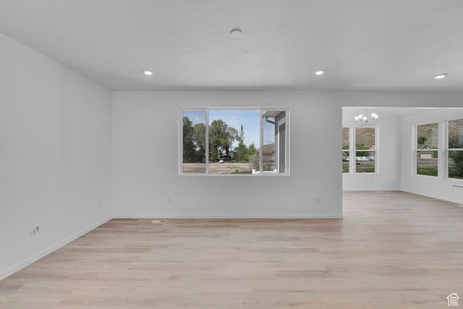 Spare room featuring plenty of natural light, a chandelier, light wood-style flooring, and recessed lighting | Image 25