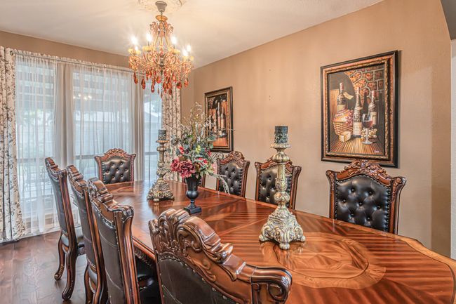 Dining space with a chandelier and dark wood finished floors | Image 16
