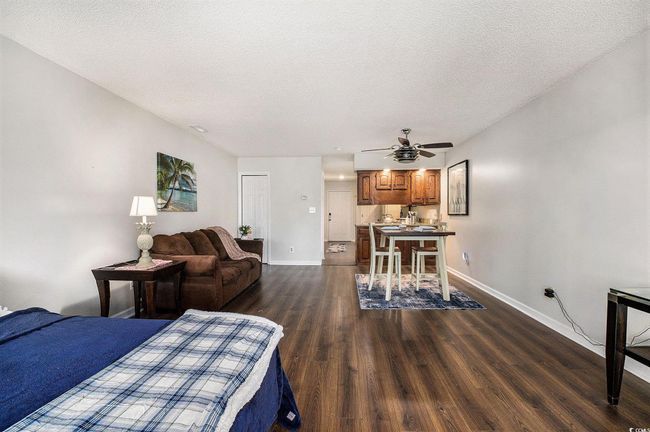 Bedroom featuring dark wood-style flooring, a textured ceiling, and ceiling fan | Image 19