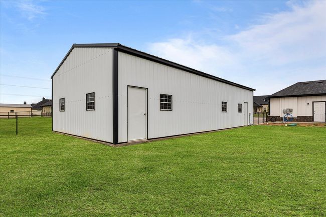 View of pole building with fence and a lawn | Image 5