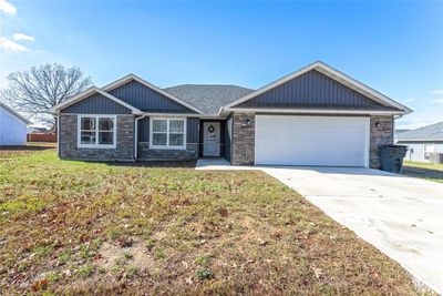 View of front of home with central air condition unit, a garage, and a front lawn | Image 3