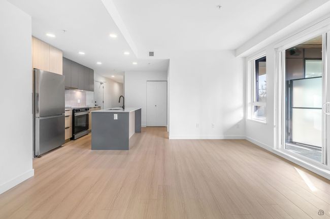 Kitchen with freestanding refrigerator, light wood-style floors, electric range, modern cabinets, and a sink | Image 6