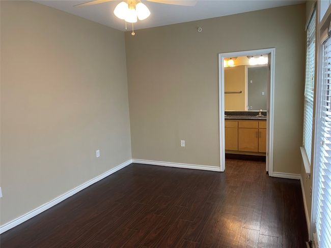 Empty room featuring ceiling fan and dark wood-style floors | Image 18