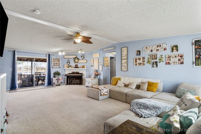 The living area features sliding glass doors that lead to the covered patio and above ground pool | Image 13