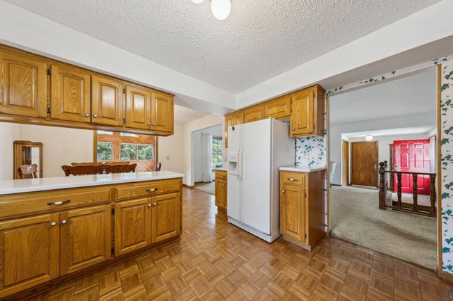 Main level kitchen with a large breakfast bar and mosaic hardwood floors | Image 7