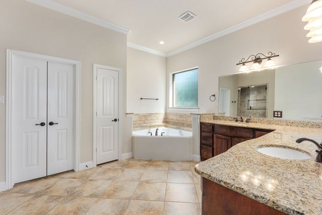 Bathroom featuring a bath, a shower stall, ornamental molding, and a sink | Image 25