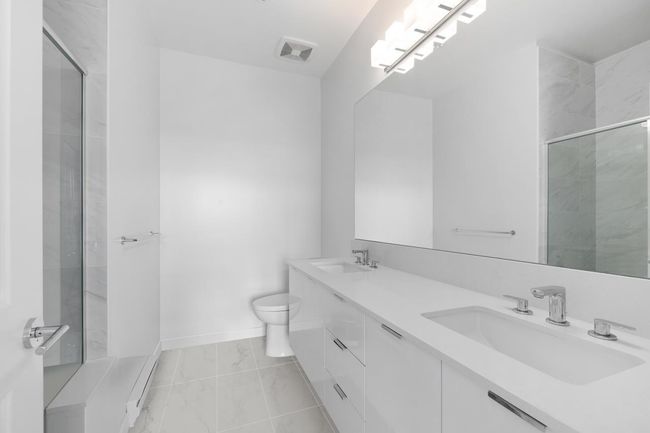 Full bathroom with visible vents, a sink, a shower with shower door, and toilet | Image 17