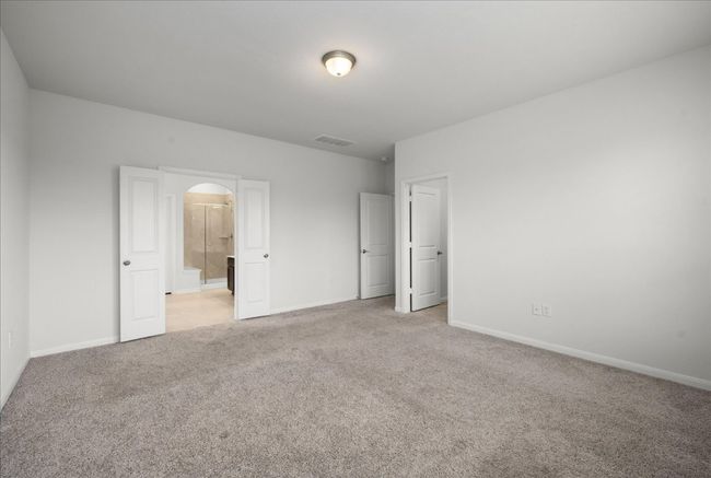 Primary bedroom featuring light carpet, arched walkways, and baseboards | Image 22