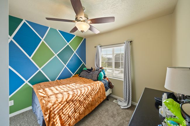 Bedroom with carpet flooring, ceiling fan, and a textured ceiling | Image 20