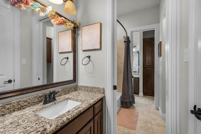 Bathroom with vanity, shower / tub combo with curtain, and tile patterned flooring | Image 28