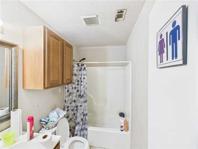 Bathroom featuring shower / bath combination with curtain, vanity, and a textured ceiling | Image 7