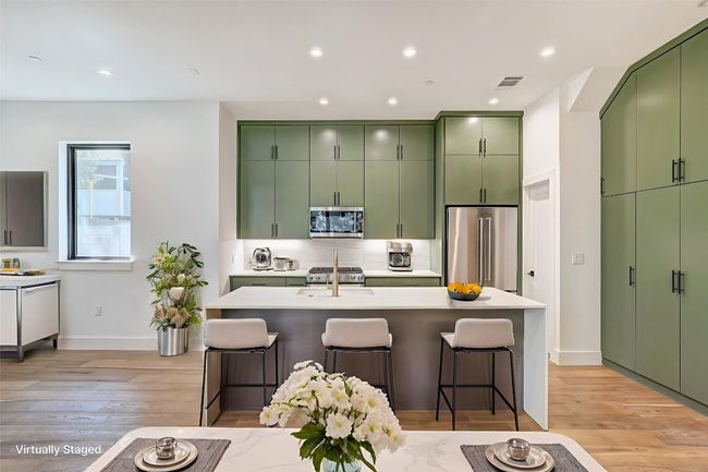 Kitchen featuring appliances with stainless steel finishes, green cabinets, light wood-style flooring, and recessed lighting | Image 7