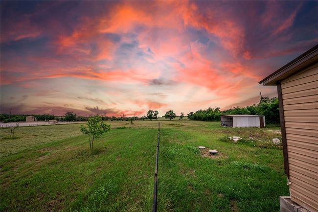 Yard at dusk featuring an outdoor structure and a rural view | Image 29