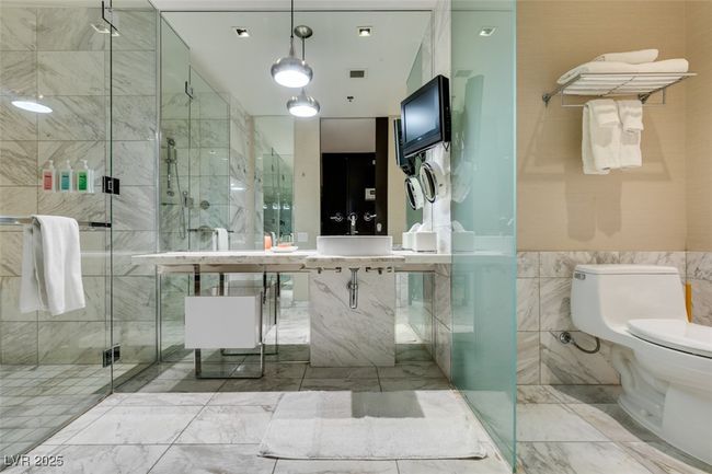 Full bathroom featuring marble finish flooring, a shower stall, and tile walls | Image 29