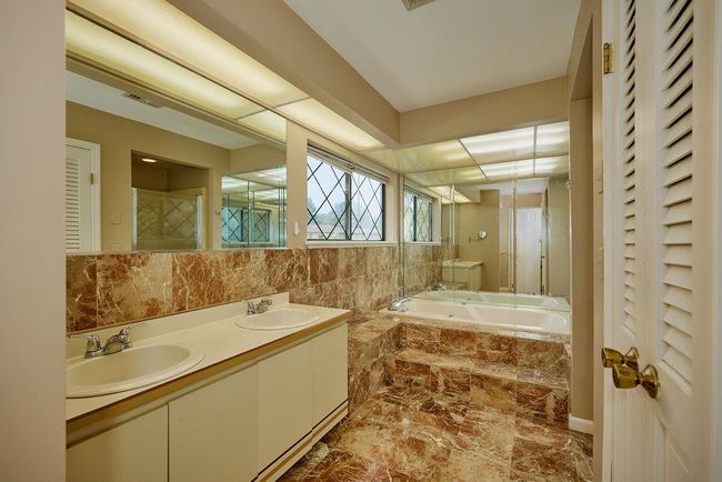 Full bathroom featuring a closet, a garden tub, marble finish floors, and double vanity | Image 20