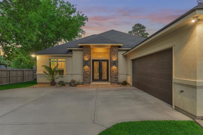 Accent lighting along the stonework and corners of the home enhances its architectural charm, creating a warm and inviting ambiance, especially in the evenings. | Image 5