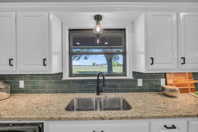 Kitchen featuring a sink, white cabinets, and tasteful backsplash | Image 20