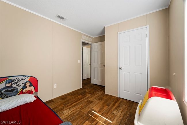 Bedroom with ornamental molding and dark wood-type flooring | Image 19