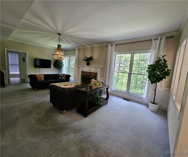 Kitchen with high end refrigerator, white cabinetry, ornamental molding, light LVP flooring | Image 23