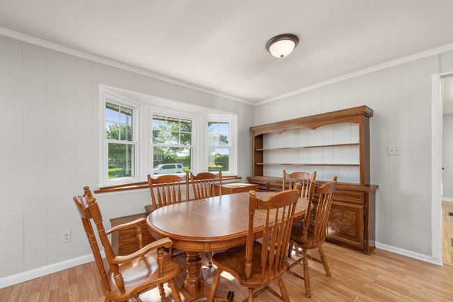 Dining area with light wood-style floors and ornamental molding | Image 11