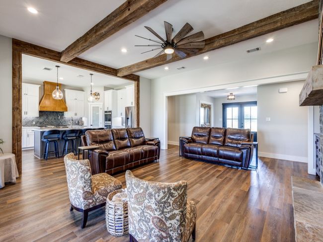 Open floor plan creates an effortless flow through the home. Notice the extensive recess lighting. Additional barn wood beams accent the cased opening into the glamourous kitchen. Luxury vinyl plank floors give you the rich warm look of wood but are so country-home friendly for kids, dogs, and quick clean ups. | Image 6