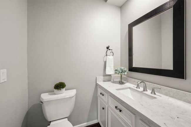 Updated powder bath includes toilet, flooring, counters, sink, faucets and mirror. | Image 14