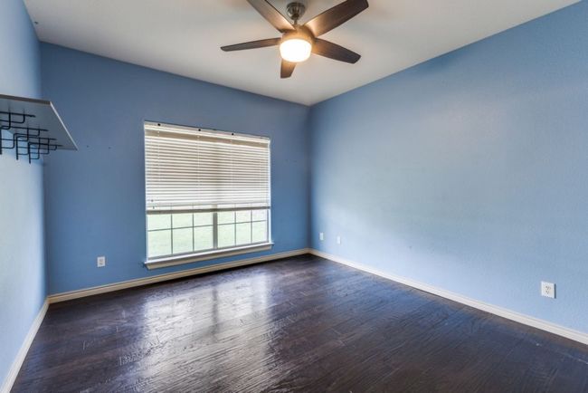 Unfurnished room with ceiling fan, baseboards, and wood finished floors | Image 24