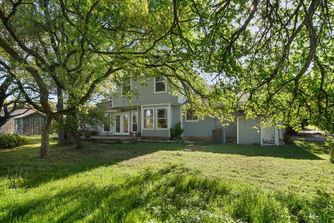 Back of property. French doors open to patio. | Image 21