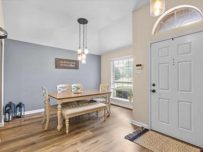 Dining area with vaulted ceiling and wood finished floors | Image 7