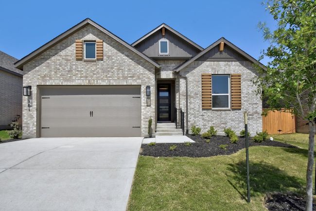 Craftsman-style house with concrete driveway, an attached garage, brick siding, and board and batten siding | Image 24