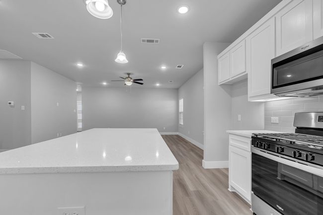 Kitchen featuring visible vents, a ceiling fan, tasteful backsplash, appliances with stainless steel finishes, and a center island | Image 12