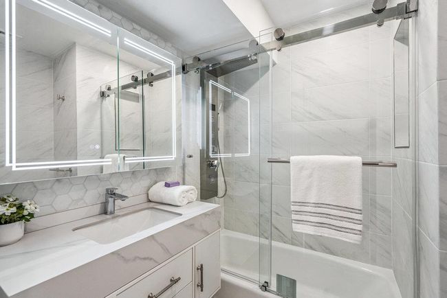Full bath featuring combined bath / shower with glass door, tasteful backsplash, and vanity | Image 22