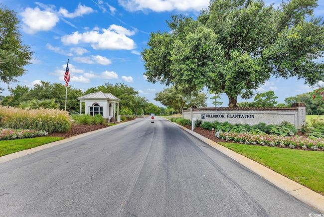 View of asphalt street featuring a gated entry and curbs | Image 35