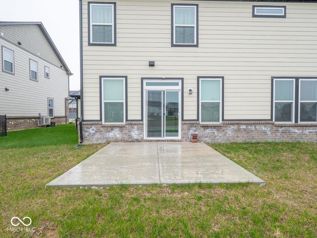 rear view of house with brick siding, a yard, and a patio area | Image 57