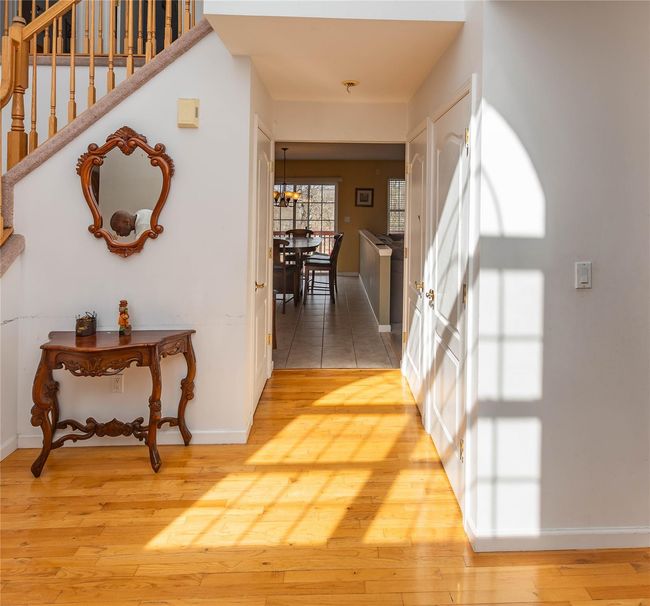Corridor with stairway, baseboards, light wood-type flooring, and a chandelier | Image 8