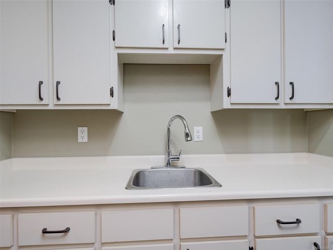 Kitchen featuring light countertops and white cabinets | Image 9